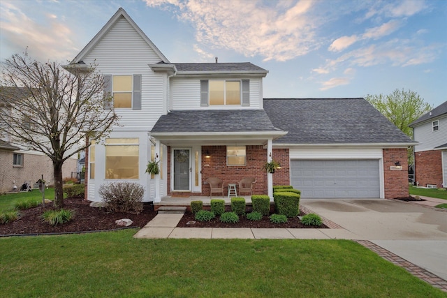 traditional home with covered porch, driveway, roof with shingles, brick siding, and an attached garage