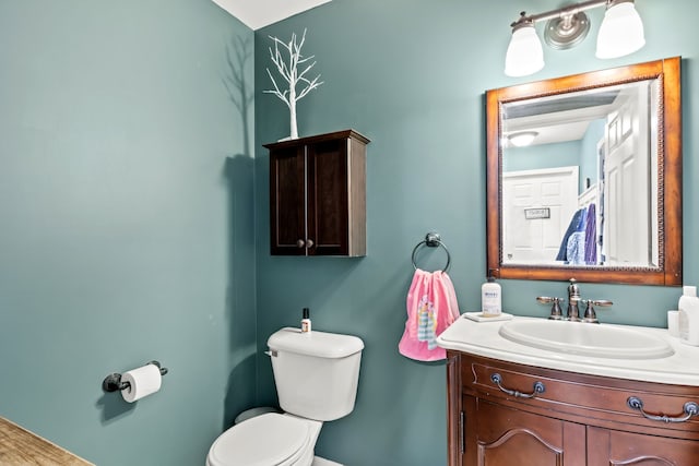 bathroom with baseboards, vanity, and toilet