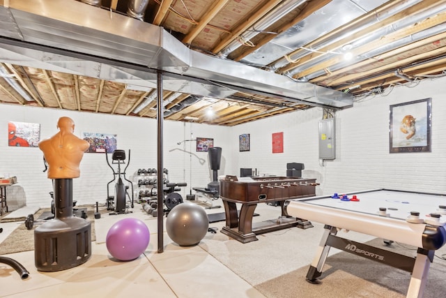 game room with brick wall and electric panel