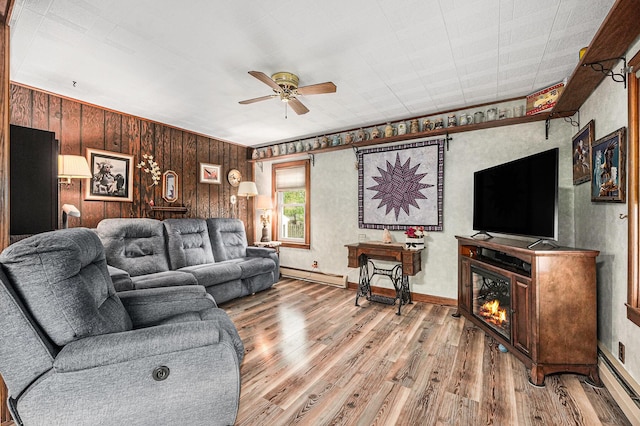 living room with baseboards, a baseboard radiator, a ceiling fan, and wood finished floors