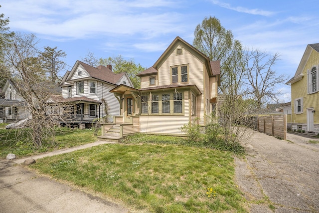 view of front of home featuring roof with shingles, fence, and a front yard