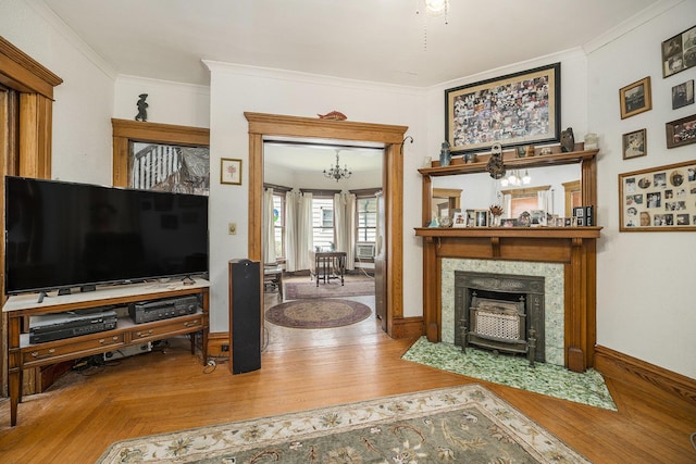 living room with crown molding, a notable chandelier, and wood finished floors