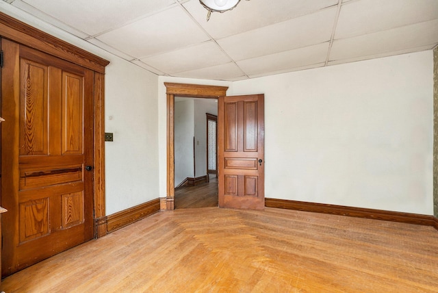 empty room with baseboards and a paneled ceiling