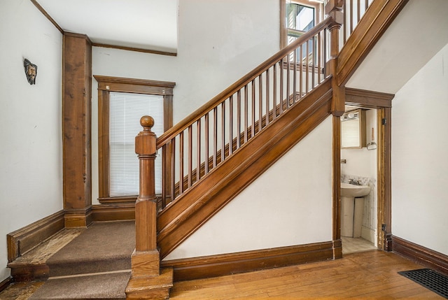 stairs with visible vents, baseboards, and wood finished floors