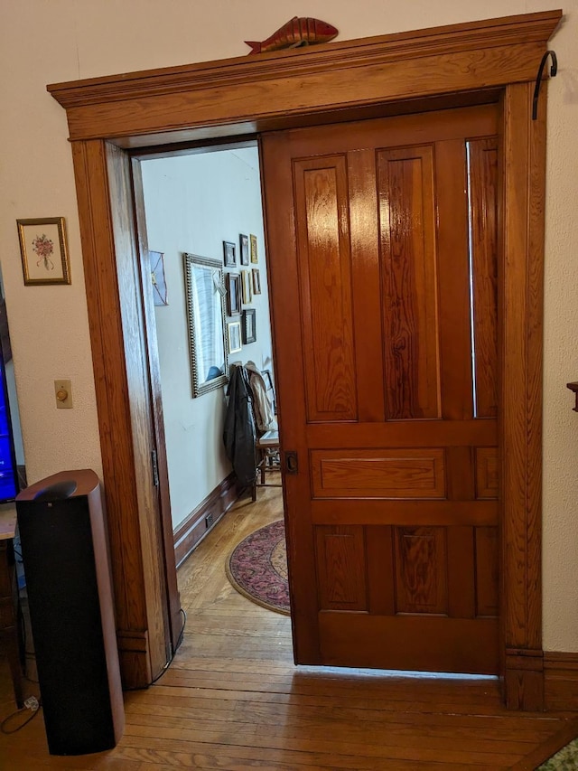 corridor featuring baseboards and light wood-style flooring
