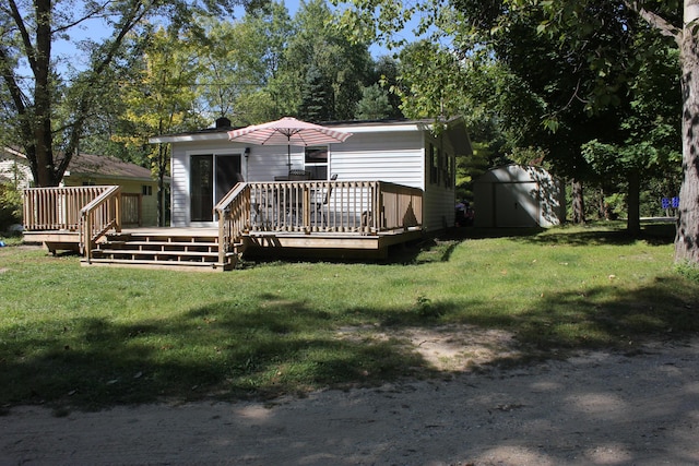 17980 1ST Callejon, Barryton, MI 49305 - rear view of house with a storage shed, an outdoor structure, a lawn, and a deck