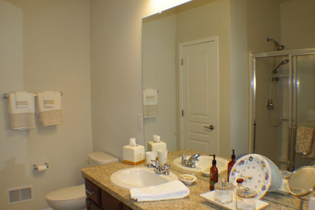 full bath with visible vents, vanity, toilet, and a shower stall