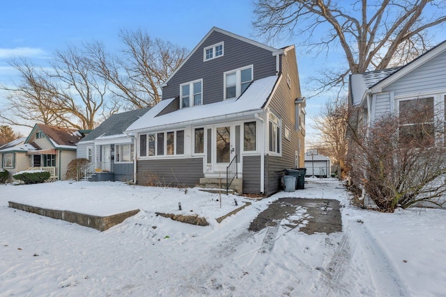 view of front facade with entry steps, an outbuilding, and a sunroom