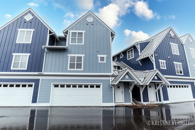 multi unit property with an attached garage, board and batten siding, a standing seam roof, and metal roof