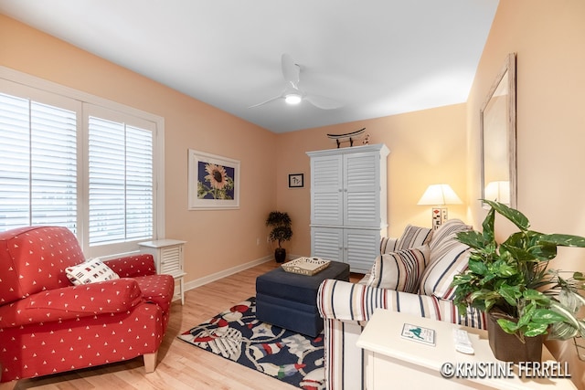 sitting room with baseboards, a ceiling fan, and wood finished floors