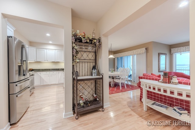 kitchen featuring white cabinets, stainless steel appliances, recessed lighting, and light wood-style flooring