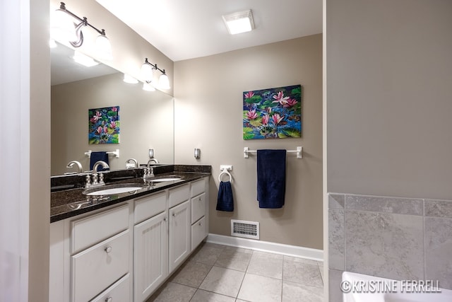 bathroom featuring visible vents, a sink, baseboards, and tile patterned floors