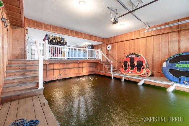 interior space featuring wooden walls and a garage door opener