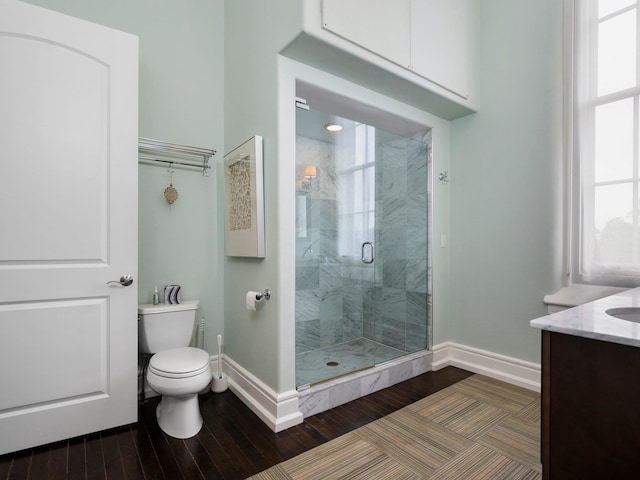 800-204 Cottageview Dr, Traverse City, MI 49684 - bathroom featuring baseboards, wood finished floors, toilet, and a shower stall