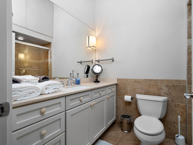 800-204 Cottageview Dr, Traverse City, MI 49684 - bathroom featuring vanity, tile patterned flooring, toilet, tile walls, and a stall shower