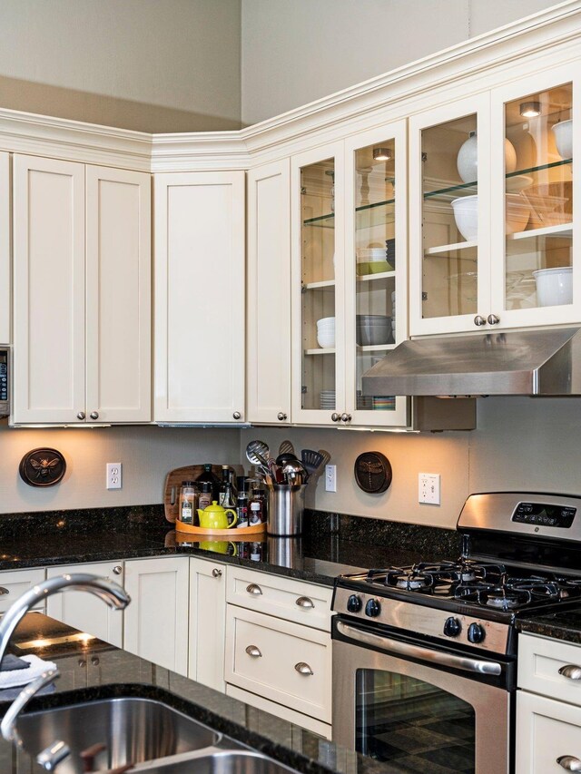 800-204 Cottageview Dr, Traverse City, MI 49684 - kitchen with appliances with stainless steel finishes, a sink, white cabinets, dark stone countertops, and under cabinet range hood