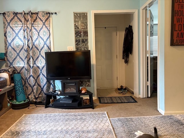 carpeted living area with baseboards