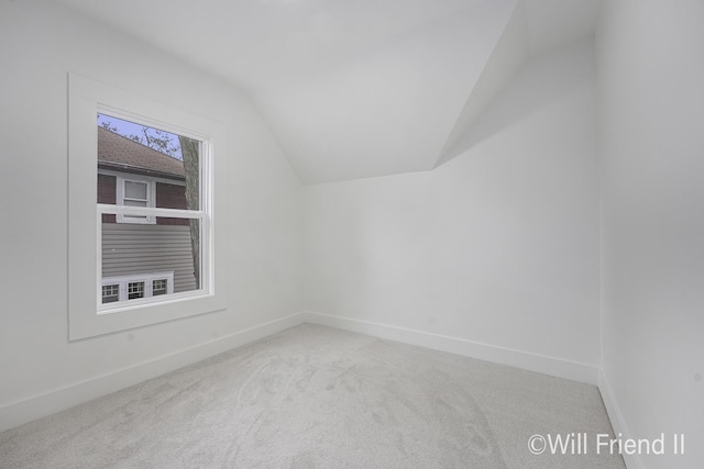 additional living space with baseboards, carpet flooring, and lofted ceiling