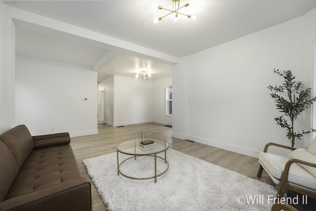 living room featuring baseboards, light wood-style flooring, and a chandelier
