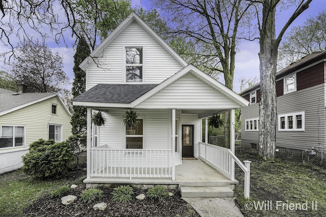 bungalow-style home featuring covered porch and a shingled roof