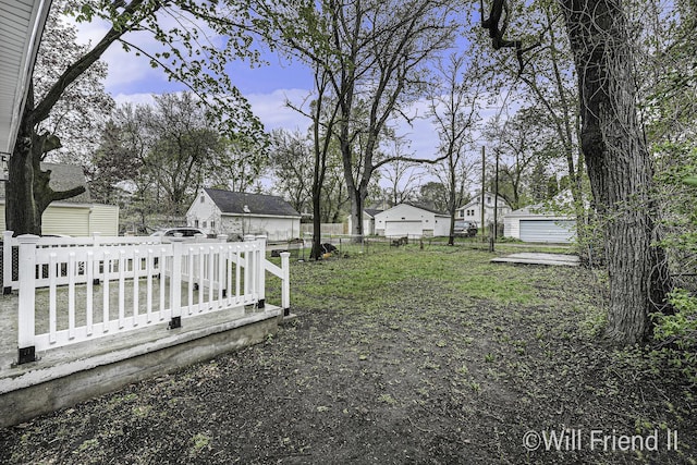 view of yard with fence, an outbuilding, and a storage unit