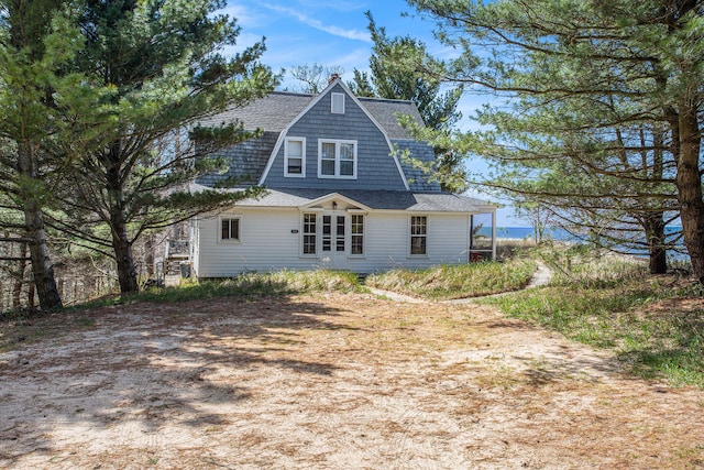 back of property featuring roof with shingles