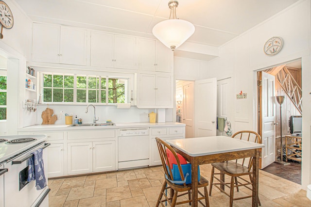 kitchen with a sink, white cabinetry, stone finish floor, and white appliances