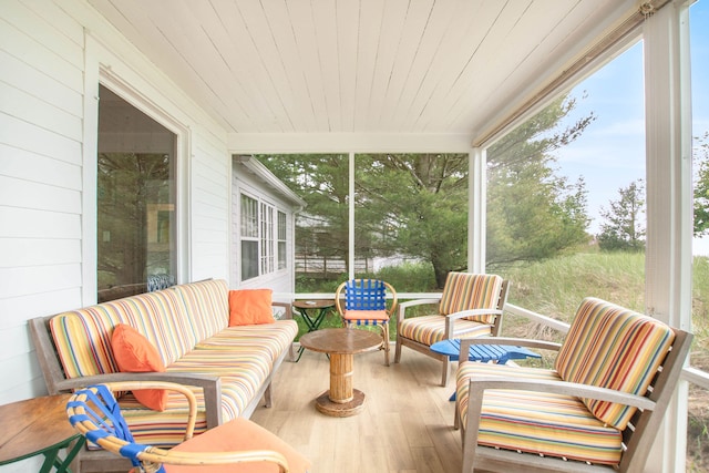 sunroom featuring wood finished floors, wooden walls, and wooden ceiling