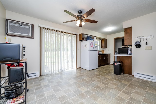 kitchen with freestanding refrigerator, a wall mounted air conditioner, light countertops, a baseboard heating unit, and a ceiling fan
