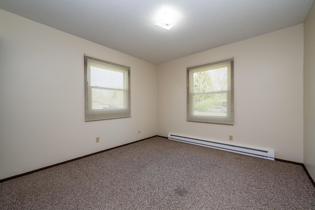 unfurnished room featuring carpet flooring, a baseboard heating unit, and plenty of natural light