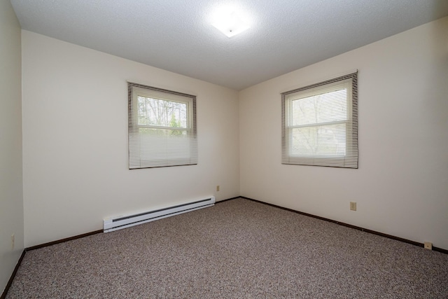 spare room featuring carpet floors, baseboards, and baseboard heating