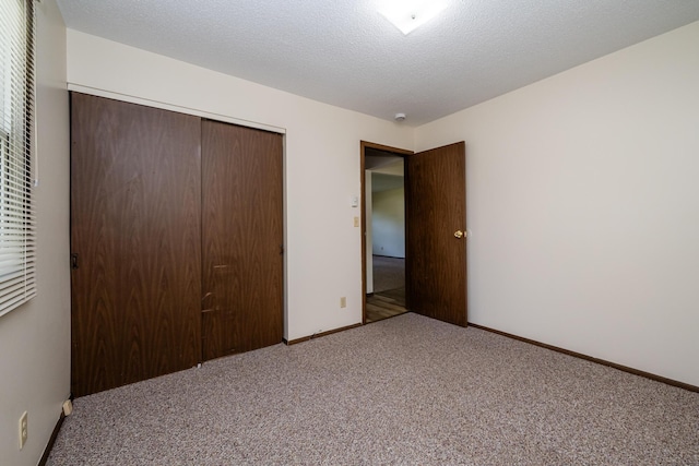 unfurnished bedroom featuring carpet floors, baseboards, and a closet