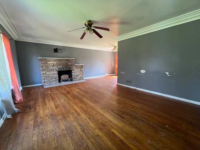 unfurnished living room with ceiling fan, ornamental molding, a stone fireplace, and wood finished floors