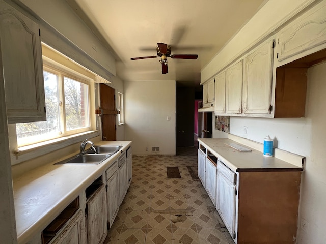 kitchen with light countertops, ceiling fan, a sink, and light floors