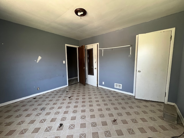 unfurnished bedroom with baseboards, visible vents, and a closet