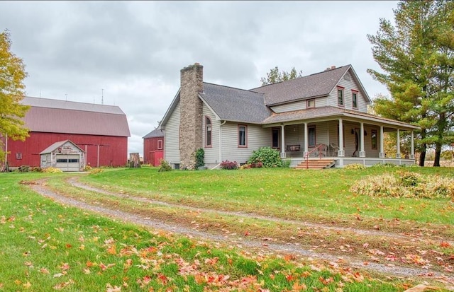 8390 E Pittsburg Rd, Durand, MI 48429 - view of side of home featuring covered porch, an outdoor structure, a yard, and a chimney