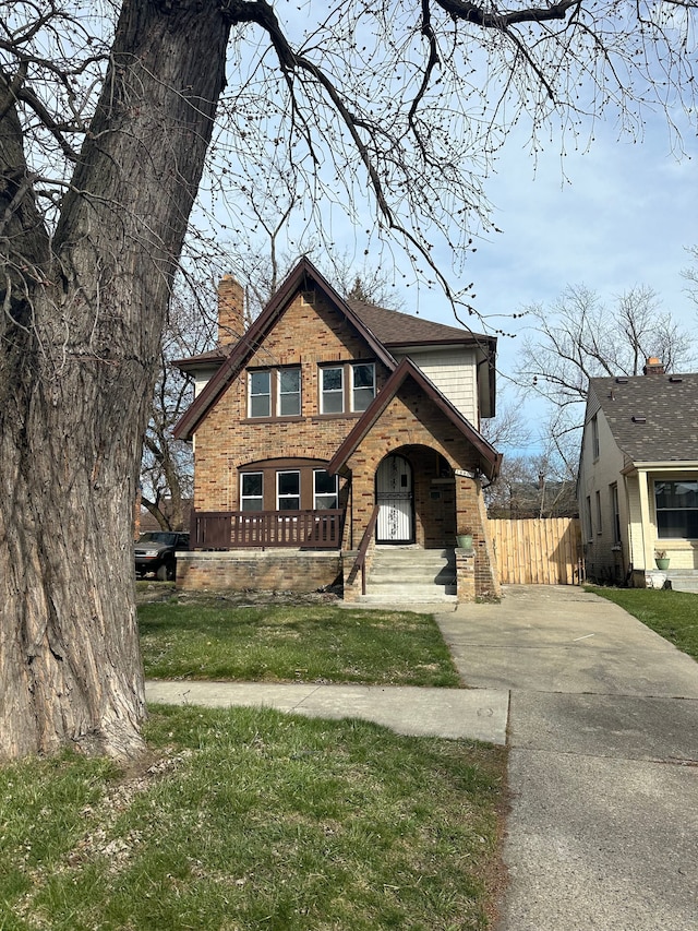 view of front facade with a front lawn, aphalt driveway, fence, and a chimney