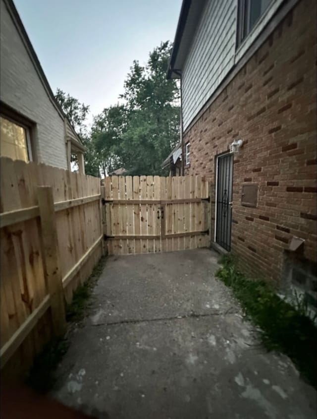 view of home's exterior with brick siding, fence, and a patio