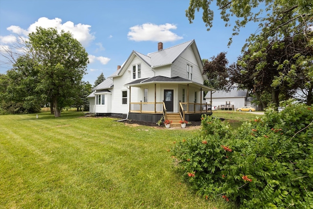 rear view of house with a yard and a chimney