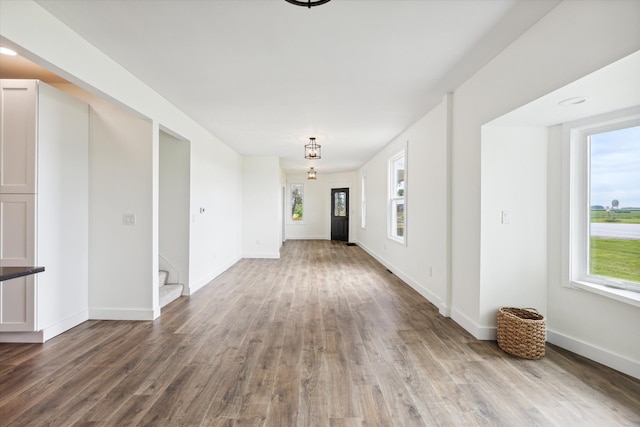 interior space with baseboards, wood finished floors, and stairway