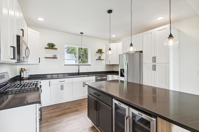 kitchen featuring open shelves, dark countertops, white cabinetry, a sink, and appliances with stainless steel finishes