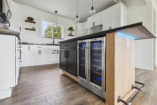 kitchen featuring open shelves, wine cooler, wood finished floors, dark countertops, and white cabinets