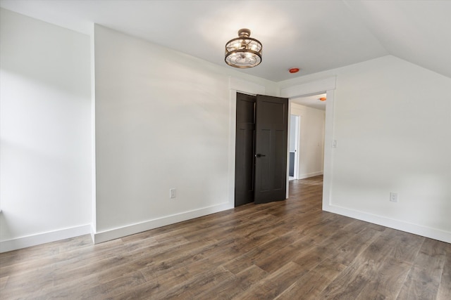 interior space with baseboards, dark wood-style flooring, and lofted ceiling