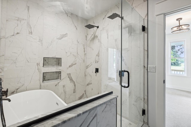 bathroom with baseboards, a marble finish shower, and a soaking tub