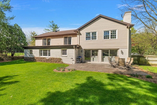 rear view of house featuring a patio, a lawn, fence, and a chimney