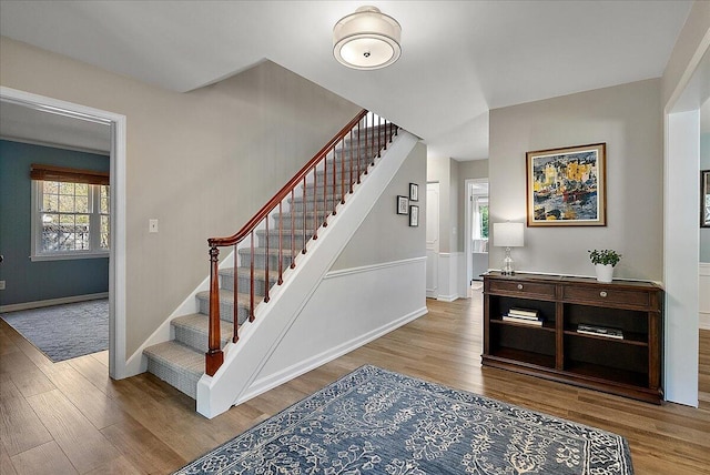 staircase featuring baseboards and wood finished floors