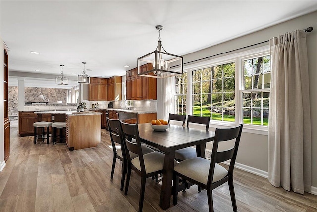 dining space with an inviting chandelier, baseboards, recessed lighting, and light wood-type flooring