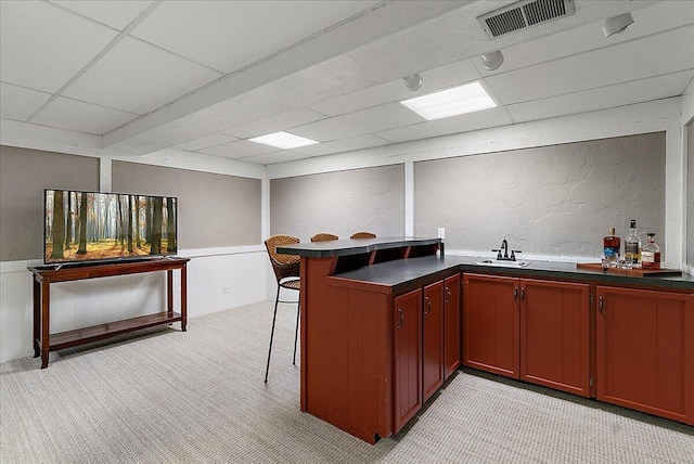 bar featuring a textured wall, a drop ceiling, light carpet, and visible vents