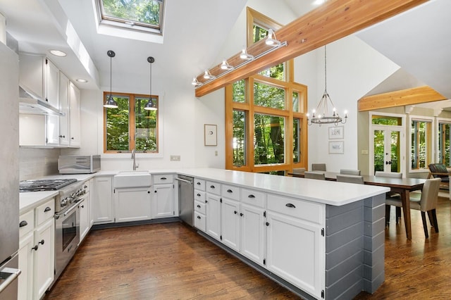 kitchen featuring a peninsula, high vaulted ceiling, white cabinetry, a sink, and stainless steel appliances