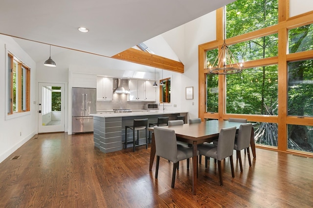 dining space featuring dark wood-style flooring, vaulted ceiling, an inviting chandelier, and visible vents